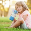Adorable elephant character head water bottle held by a child outdoors, demonstrating kid-friendly design and size.