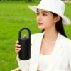 Lifestyle photography of a stylish woman holding the black arch handle bottle outdoors, demonstrating fashion utility.