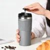 Portable all-in-one handbrew coffee mug being used to press fresh coffee in a professional office setting.
