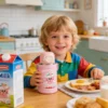 Lifestyle photography of a child with a pink titanium insulated cup during breakfast, demonstrating kid-friendly ergonomics.
