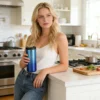 Lifestyle photography of a woman holding a gradient blue travel mug in a modern kitchen setting, showing ergonomic grip.